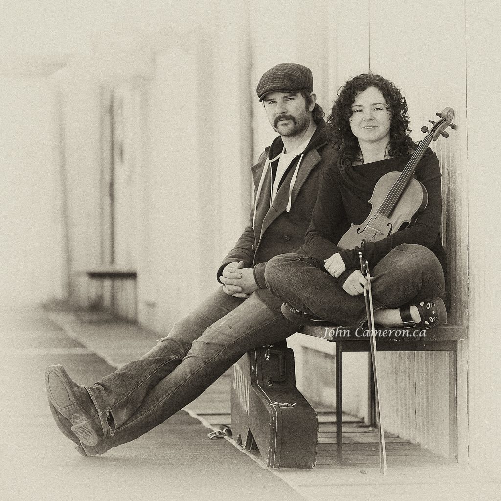 Zav and Daniel sitting on the Ganges Boardwalk ©johncameron.ca